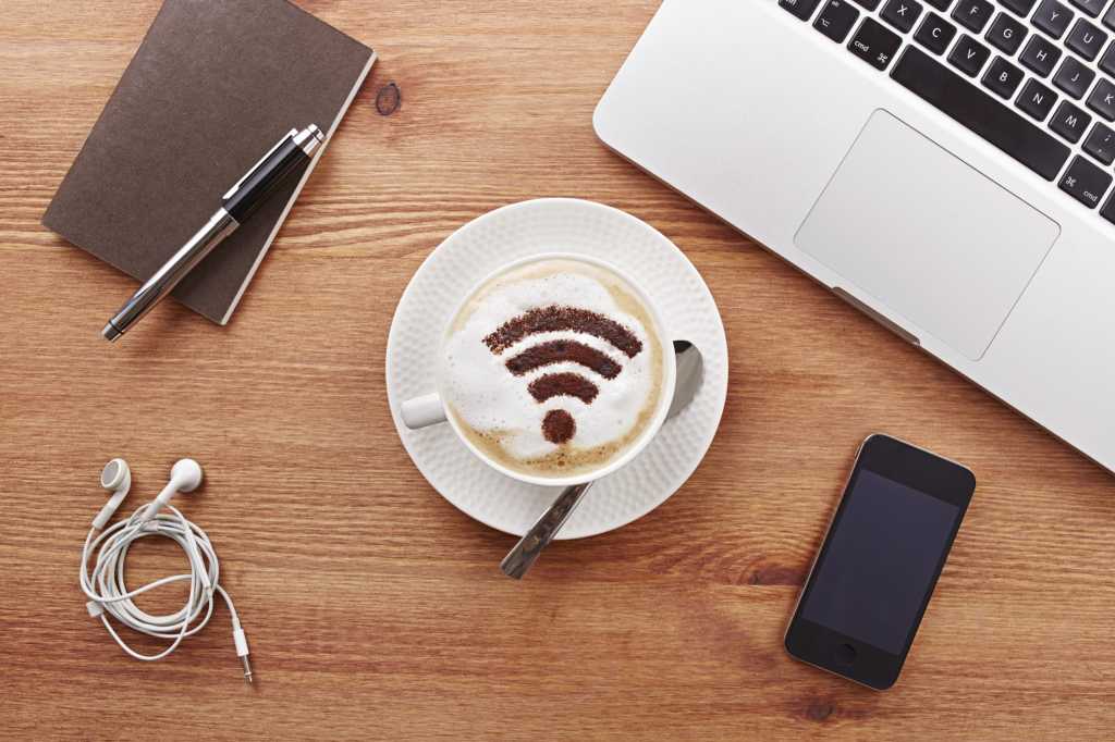 Still life of mobile devices on desk with coffee with wifi symbol